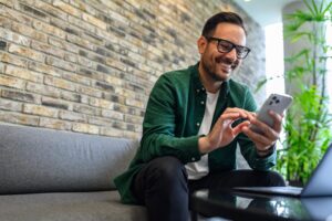 Mann mit Telefon in der Hand zeigt, wie einfach die mobile Zugangskontrolle ist