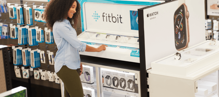 Frau am Fitbit-Display im Einzelhandelsgeschäft