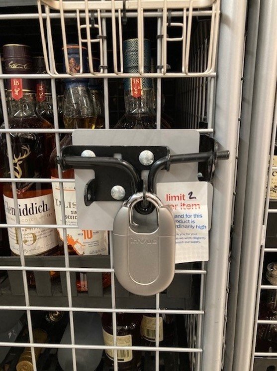 Padlock Schutz von Spirituosenflaschen in einem Käfig in einem Meijer-Markt