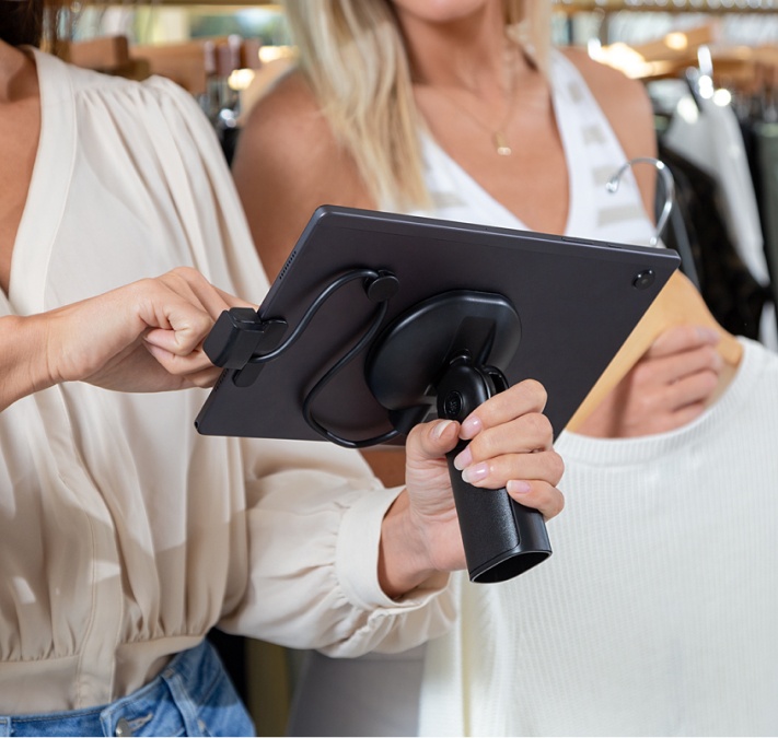 Zwei Frauen, die eine mPOS Lösung in einer Einzelhandelsumgebung verwenden.