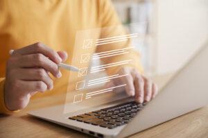Ein Einzelhandelsmanager füllt auf einem Laptop eine Checkliste für ein Audit zur Verlustprävention aus.
