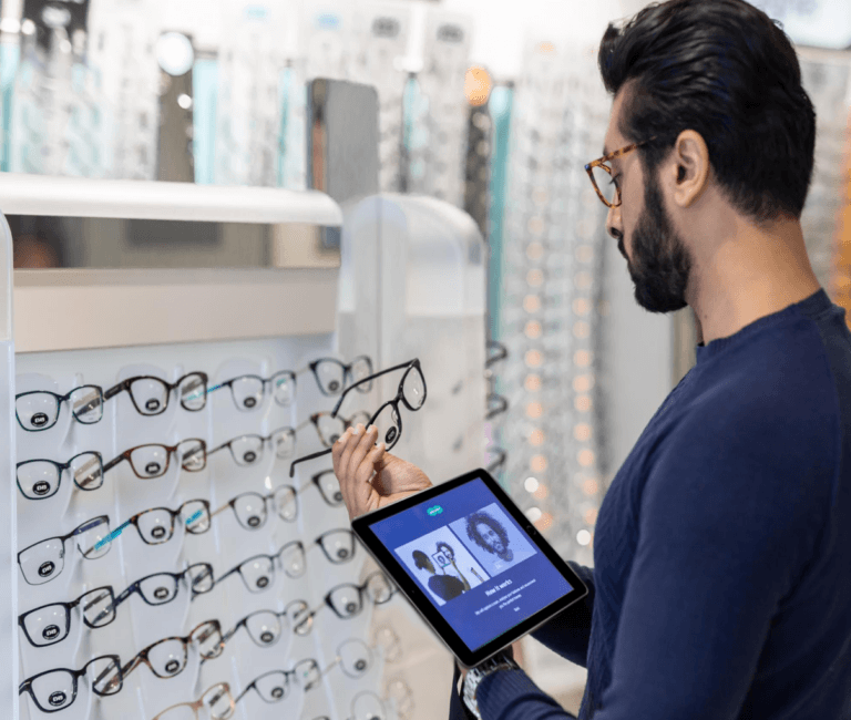 Mann hält eine Brille und ein Tablet in der Hand