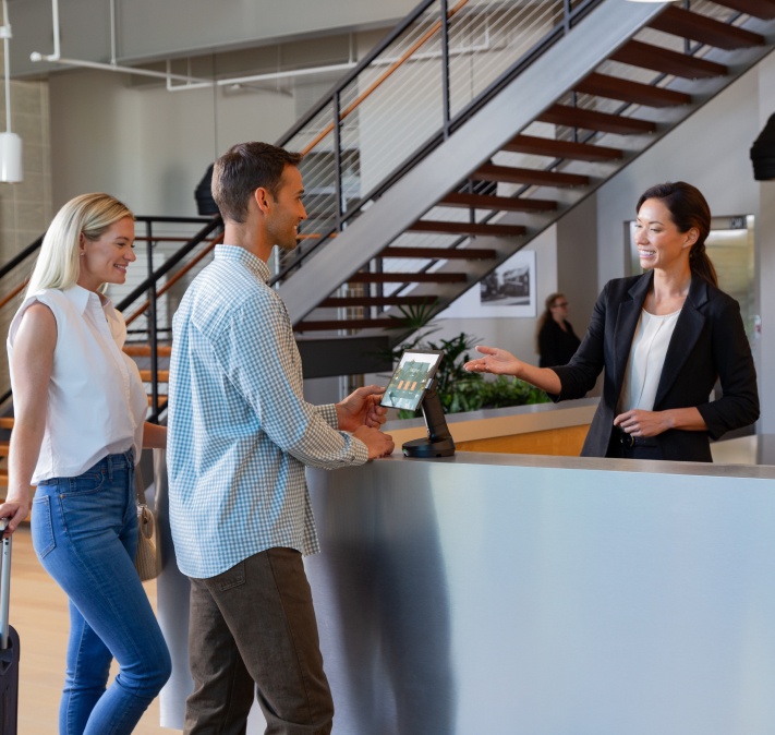 Zwei Frauen und ein Mann mit einem NE150 Convertible POS Stand