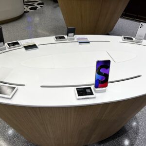 Weißer Tisch mit mobilen Geräten auf Sicherheitsständern